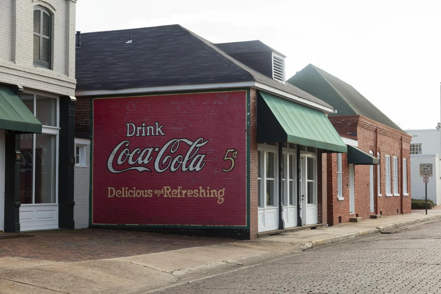 Coca-Cola ghost sign reading Drink Coca-Cola 5 cents, Delicious and Refreshing, on a brick building in Greenwood, Mississippi