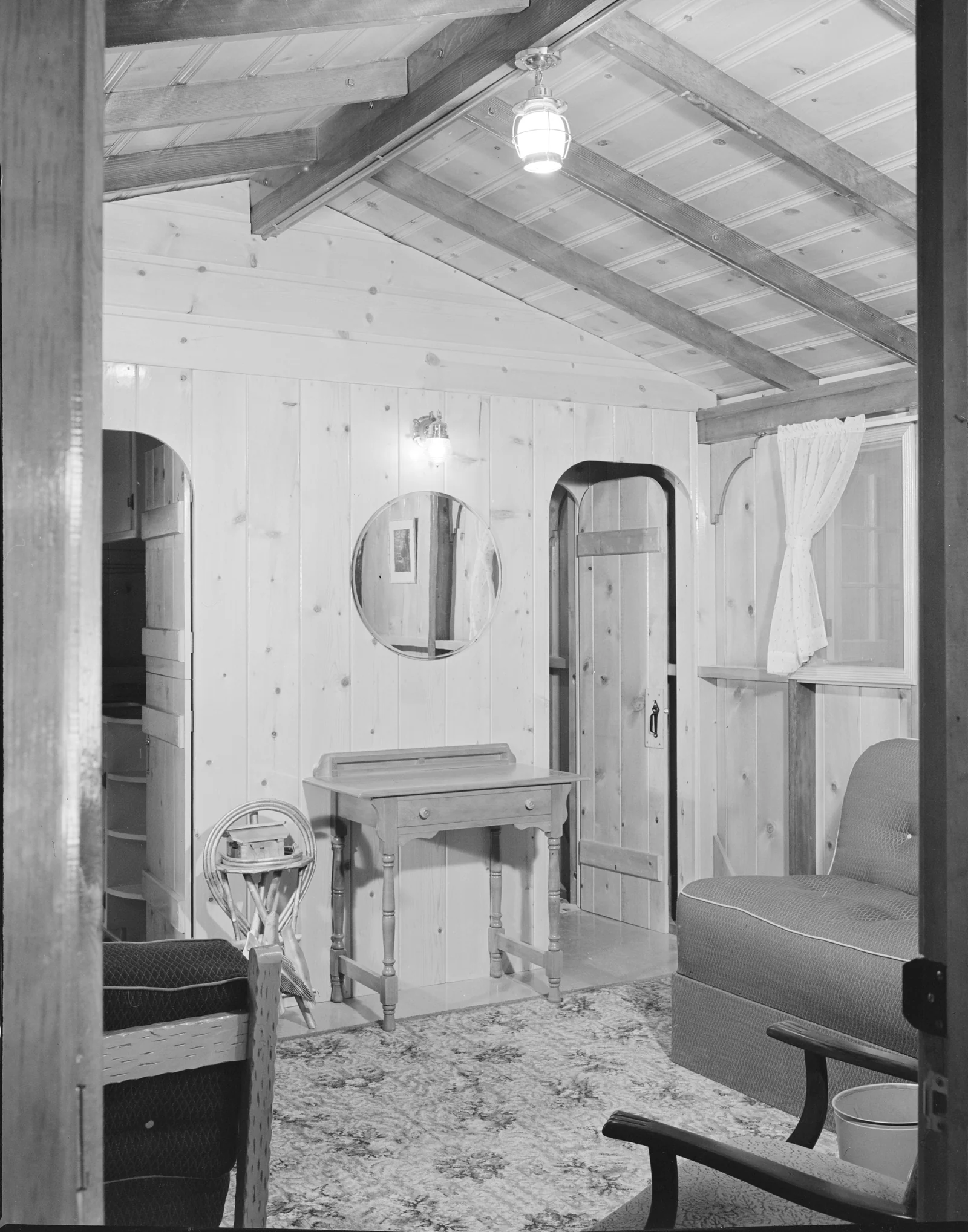 Interior of a 1942 prefabricated Westcraft war-housing home lined entirely with knotty pine wood paneling and exposed ceiling beams